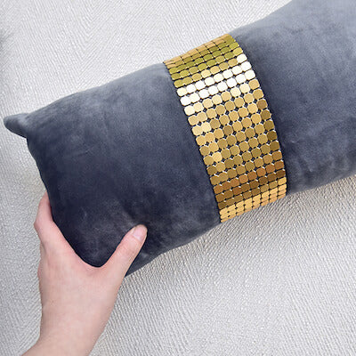 Grey velvet boudoir cushion with gold metal mesh in middle.