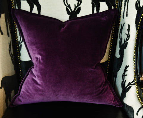 Purple Avery cushion on contrasting black and white armchair.